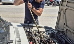 Aracın motoruna giren yılanı sopayla çıkardı!